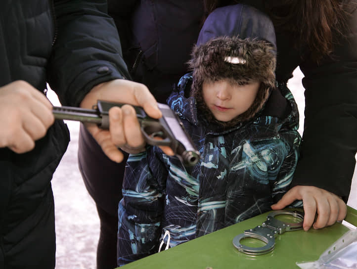 Мальчик наблюдает за разборкой пистолета Макарова во время флешмоба, устроенного силовыми ведомствами региона на стадионе &quot;Труд&quot;