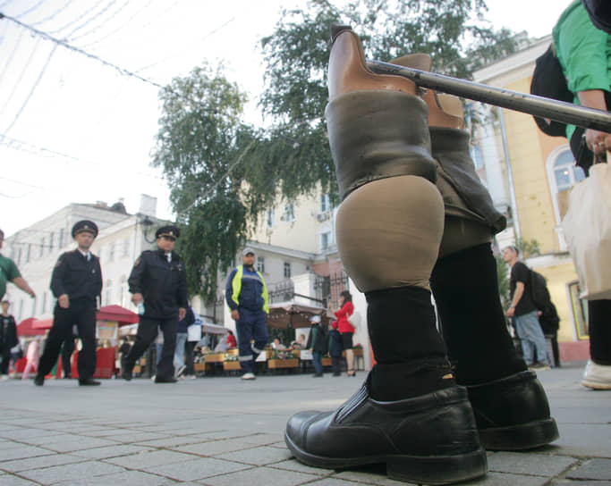 Полицейские идут мимо снятых ножных протезов инвалида Олега по Большой Покровской улице