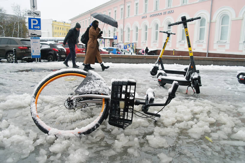 Упавший в сугроб после сильного снегопада прокатный велосипед
