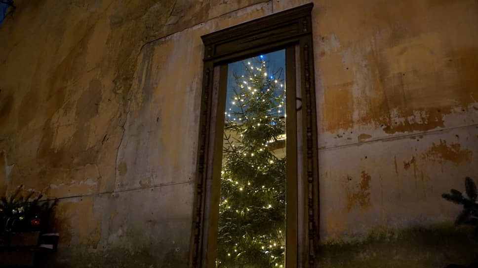 Новогодняя елка отражается в зеркале на стене старого дома в католическом квартале