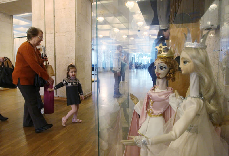 Посетители кукольного театра проходят в зрительный зал мимо витрины с персонажами спектаклей