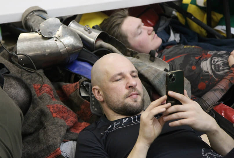 В перерыве современные рыцари отдыхают за просмотром телефонов