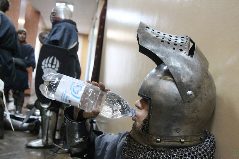 Участник пьет минеральную воду после боя