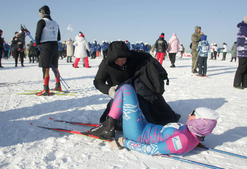 Участница лежит на снегу после финиша