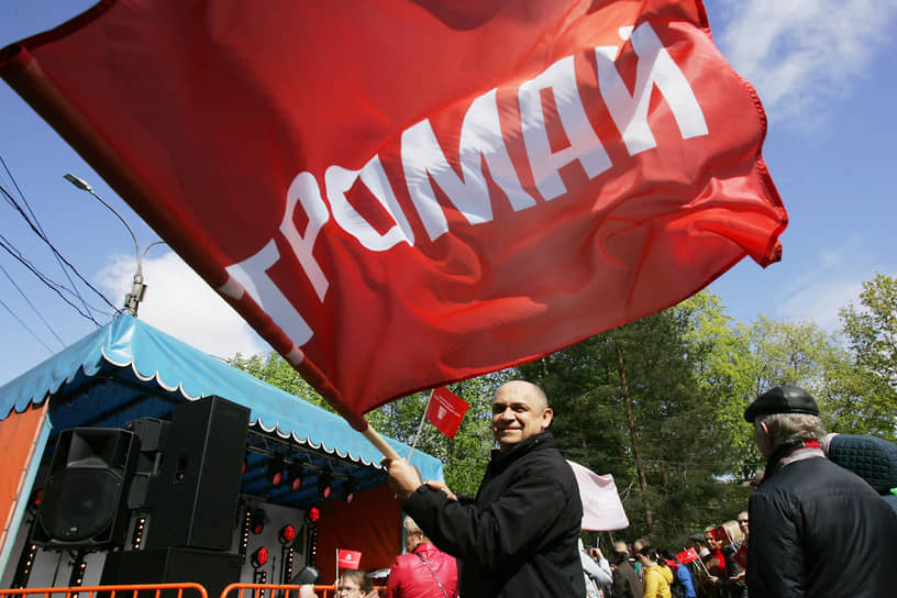 Мужчина сворачивает красное знамя с надписью «Ретромай»