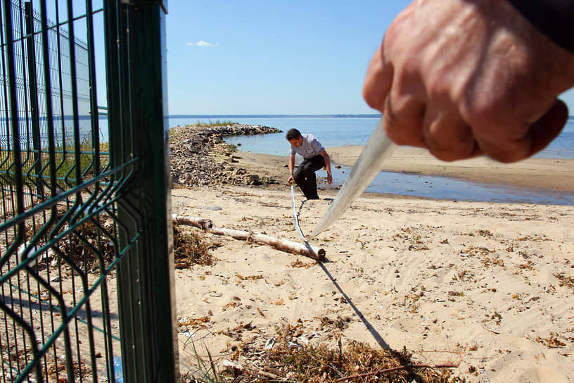 Экологи измеряют рулеткой расстояние от забора до кромки воды Горьковского моря