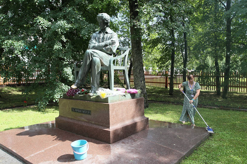Уборщица моет постамент памятника Пушкину рядом с его усадьбой