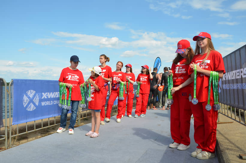 Волонтеры ждут пловцов, чтобы вручить медали