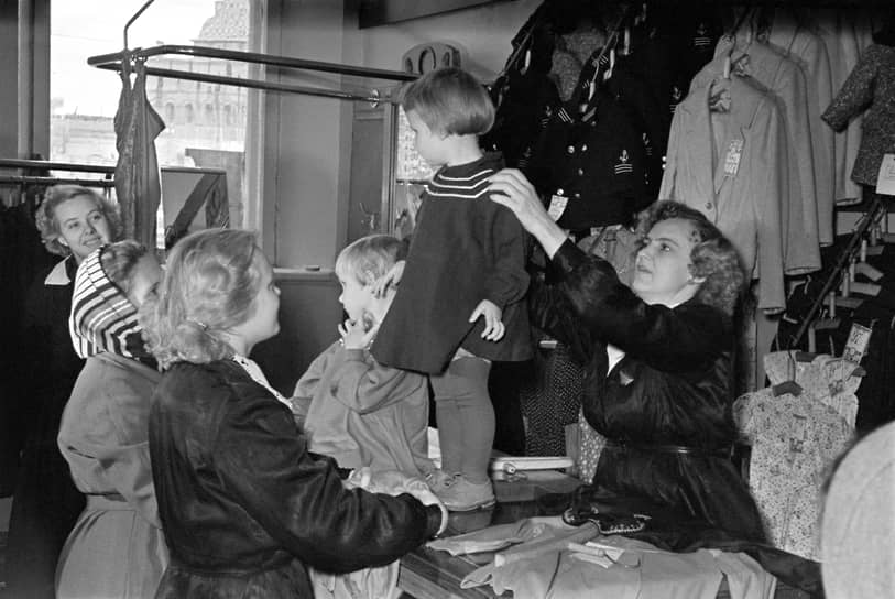 3 октября 1958 года. Продавец горьковского универмага «Детский мир» Валентина Гамаюнова примеряет маленькой покупательнице платье