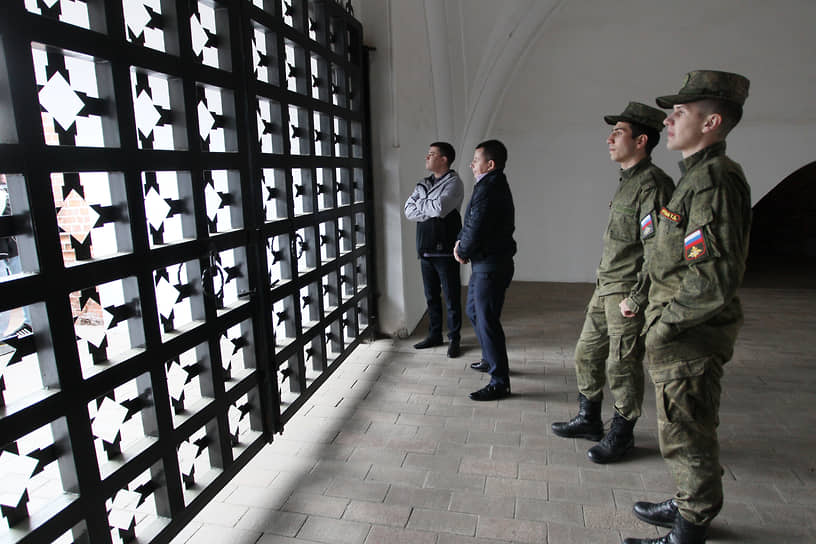 Военный патруль смотрит на парад через решетку кремлевских ворот