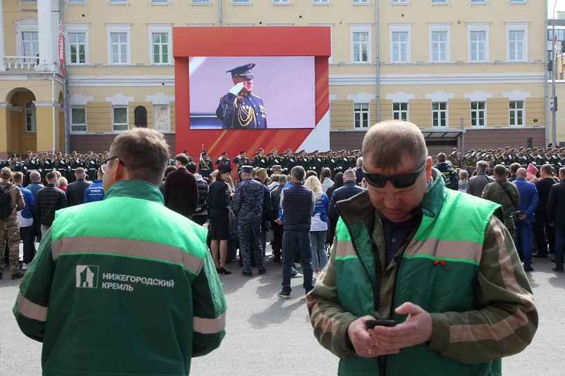 Коммунальный рабочий читает телефон во время приветствия командующего парадом