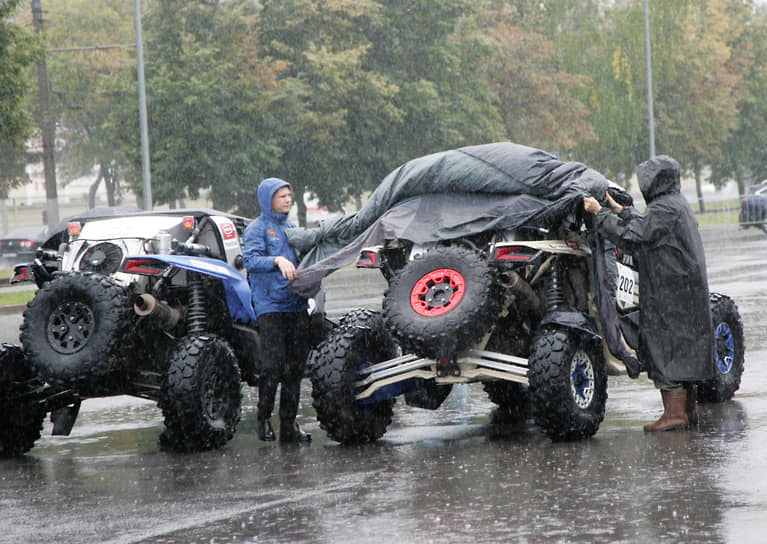 Гонщики накрывают багги от проливного дождя