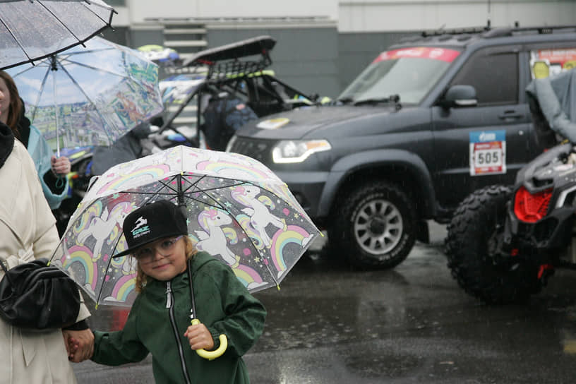 Девочка в очках рассматривает автомобили