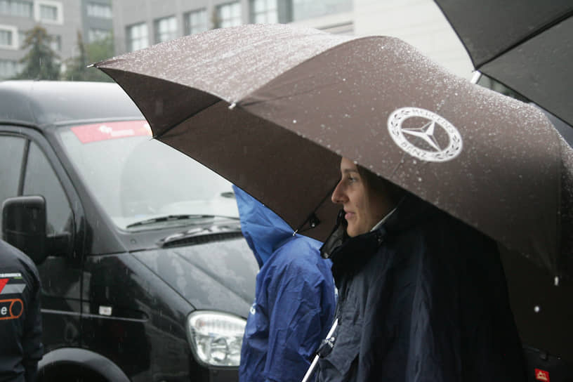 Девушка под фирменным зонтом «Мерседес»