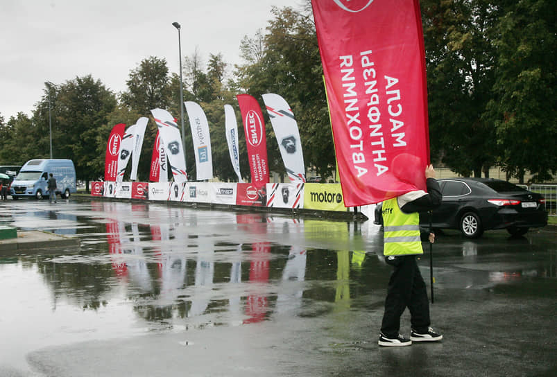 Волонтер переставляет рекламные баннеры в стартовом городке