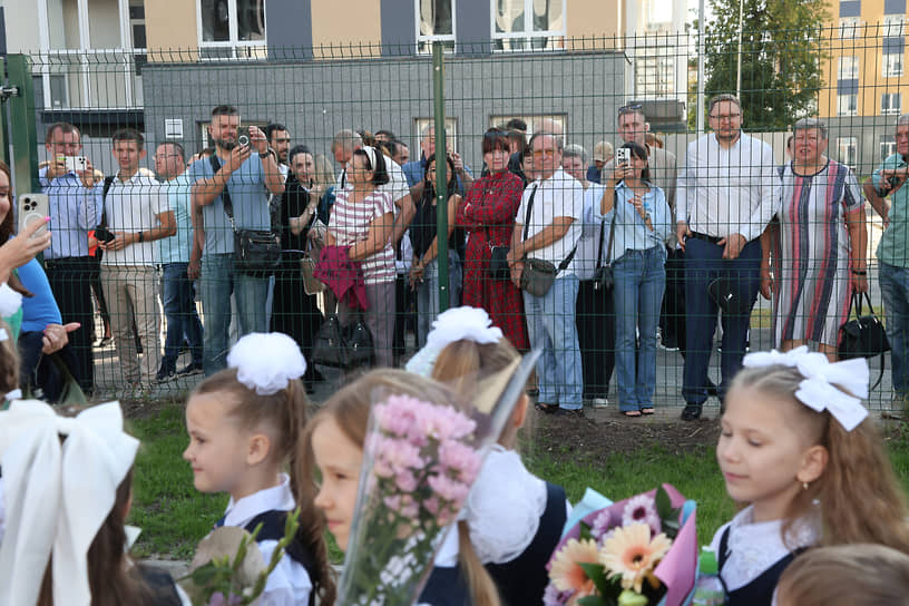 Родители наблюдают за детьми из-за ограды