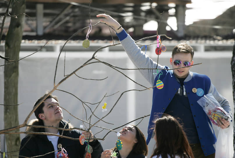 Посетитель парка «Швейцария» наряжает пасхальное дерево