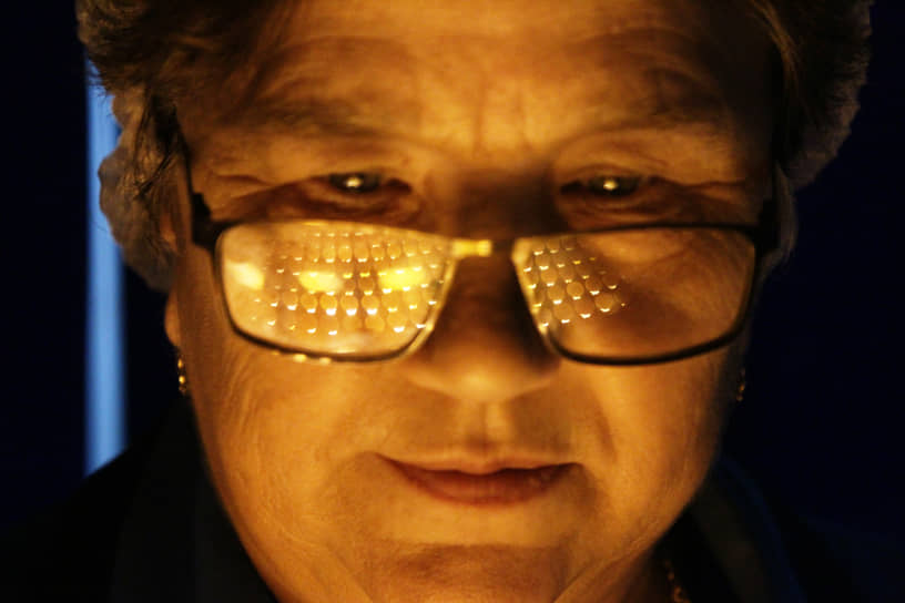 Сотрудница птицефабрики осматривает яйца