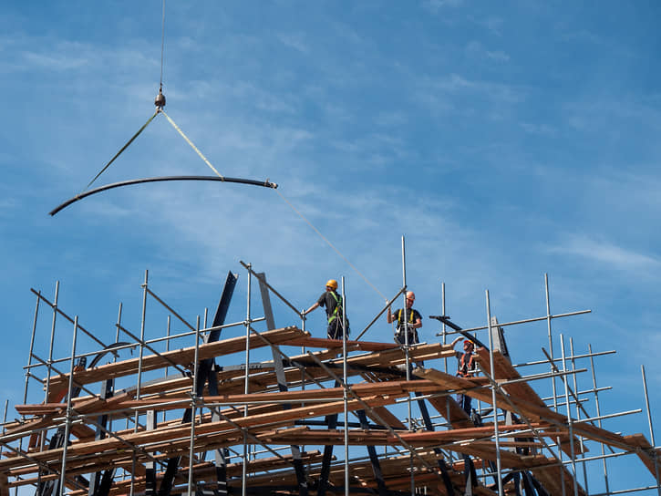 Кран опускает очередную деталь башни