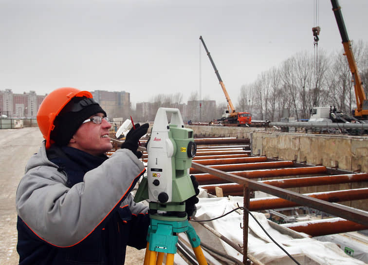 Ноябрь 2015 года. Рабочий с теодолитом на строительной площадке станции «Стрелка»