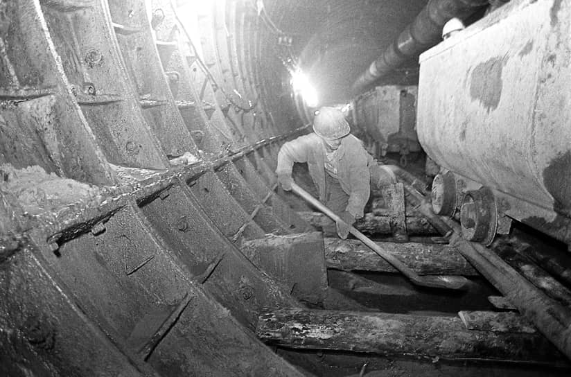 Август 1997 года. Рабочий расчищает железнодорожный путь под вагонеткой в строящемся тоннеле