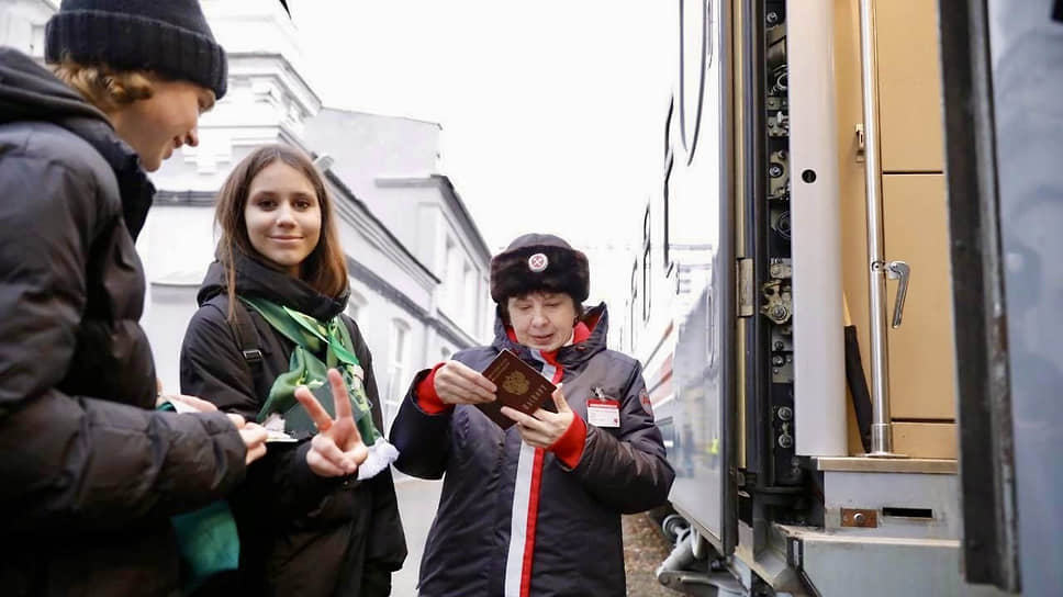 Проводница проверяет документы у пассажиров туристического поезда ГЖД