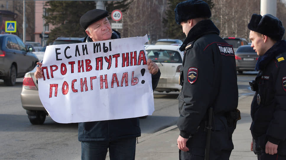 Одиночные пикеты против президента России Владимира Путина в Барнауле. Сотрудники полиции и участник пикетов с плакатом «Если ты против Путина посигналь!»