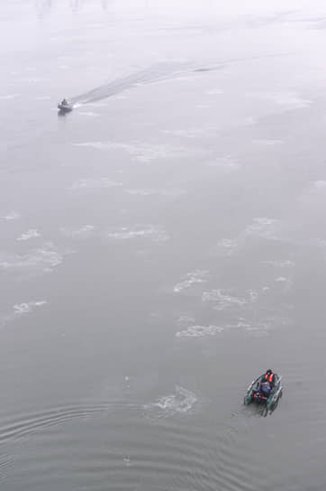 Рыбаки на моторной лодке во время начала ледостава на реке Обь в Новосибирске