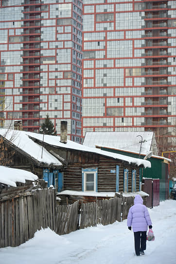 Виды Новосибирска. Старые дома частного жилого сектора на фоне современных жилых многоэтажных домов в Ленинском районе Новосибирска