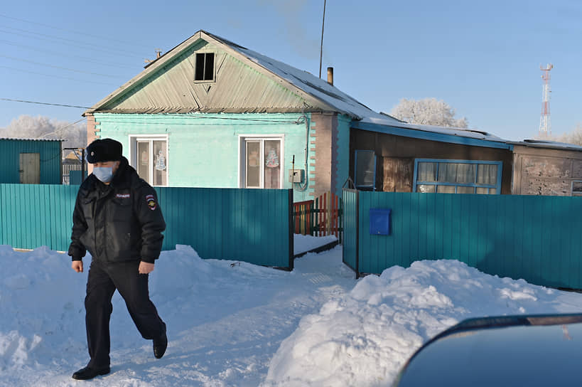 Село Юрьевка Павлоградского района Омской области, где произошло убийство трех членов семьи. Подозреваемые — 14-летняя дочь погибшей женщины и ее 17-летний друг. Сотрудник полиции у дома, где произошло убийство