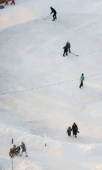 Дети катаются на коньках и играют в хоккей на одном из дворовых катков в Новосибирске