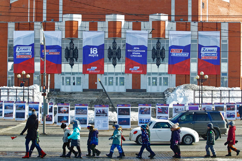 Виды Томска. Дети идут организованной колонной мимо плакатов в честь празднования посвященного восьмой годовщине воссоединения Республики Крым с Россией