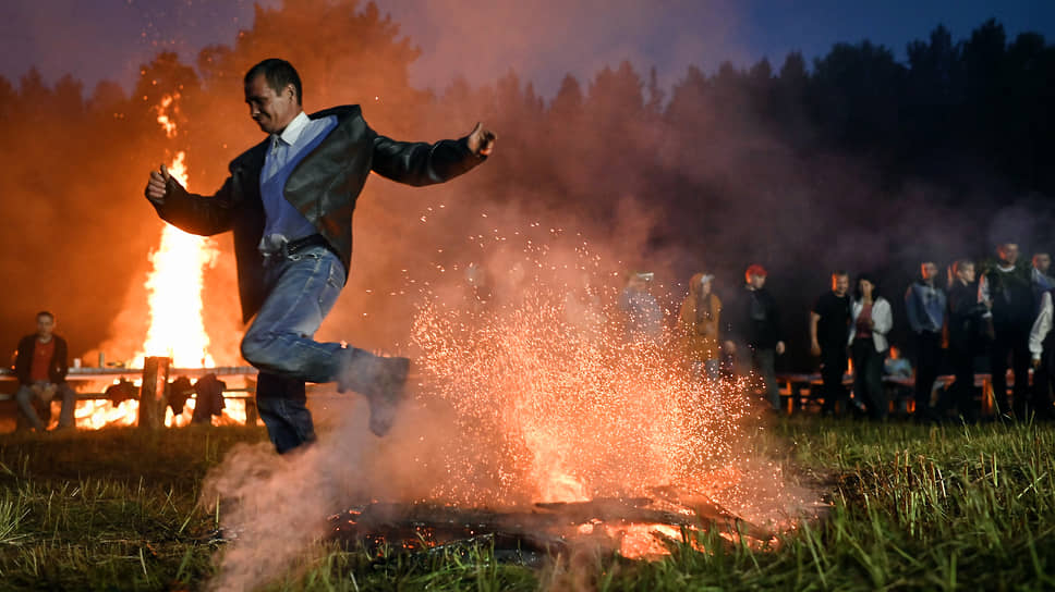 Латышский народный праздник Лиго в деревне Бобровка Омской области. Участник праздника прыгает через костер