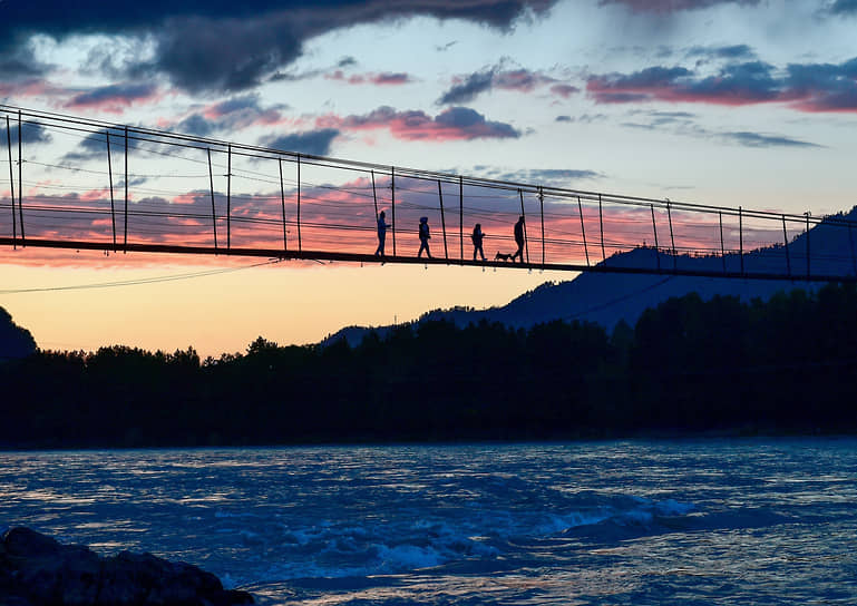 Чемальское направление — одно из самых популярных и освоенных в Республике. Здесь есть места для проживания в частном секторе, гостиницах, гостевых домах или палаточных лагерях. На фото: Туристы переходят реку Катунь по подвесному мосту в селе Анос