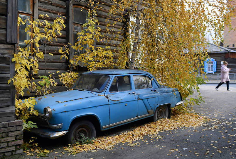 Автомобиль «Волга ГАЗ-21» на улице у старого деревянного дома в Томске