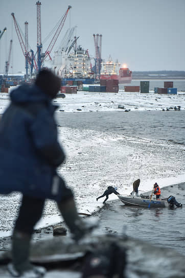 Виды Дудинки. Рыбаки на фоне работы морского порта