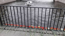 Петербуржцы несут цветы на Поцелуев мост, с которого упал автобус