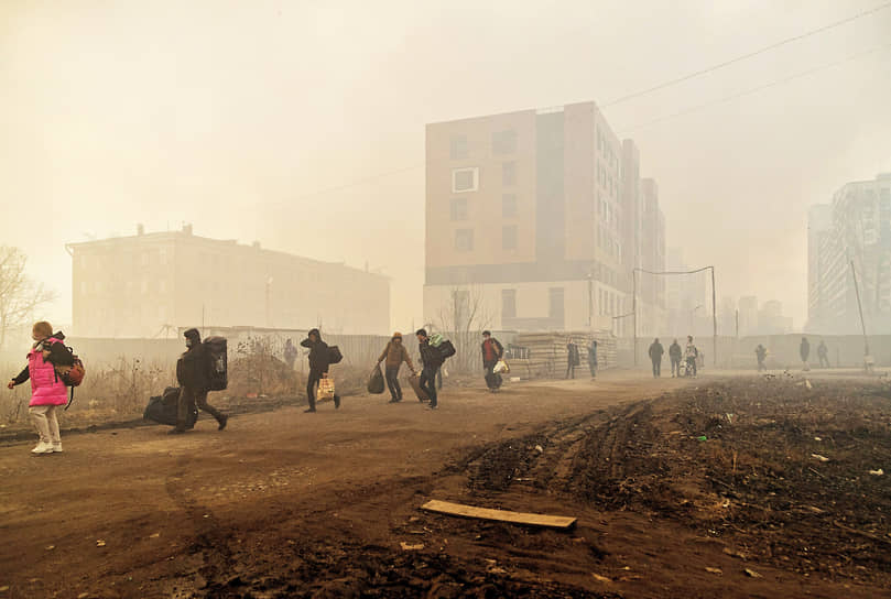 Иностранные рабочие эвакуируются из общежития, которое находится вблизи от пожара в зданиях компании &quot;Невская мануфактура&quot;
