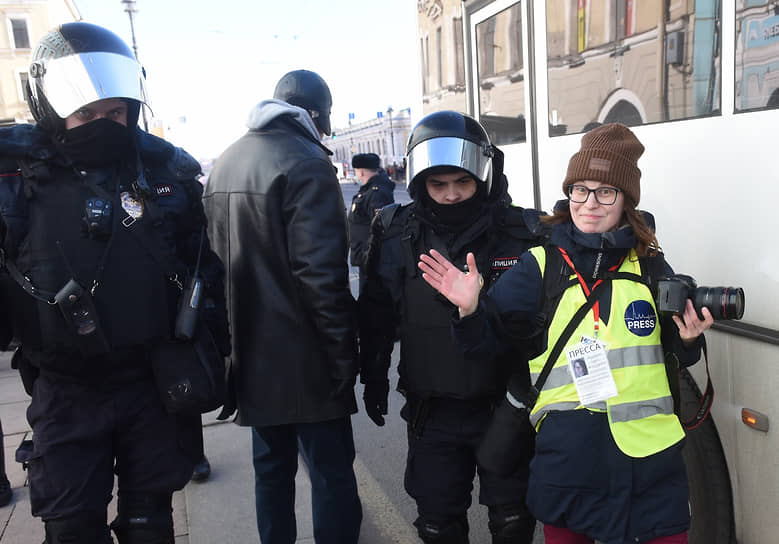 Несогласованная акция против специальной военной операции на Украине на Невском проспекте. Сотрудник полиции ведет в автобус для задержанных фотографа издания «Новая газета» в Санкт-Петербурге Елену Лукьянову