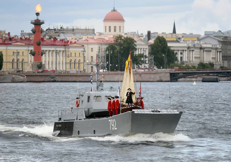 Главный военно-морской парад в честь Дня Военно-морского флота (ВМФ) России в Санкт-Петербурге в акватории реки Невы. Зрители на Университетской набережной во время парада. Десантный катер &quot;Иван Пасько&quot; с ботиком императора Петра I на параде