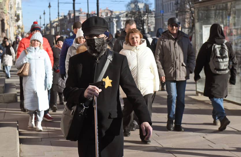 Человек в черном идет по Невскому проспекту