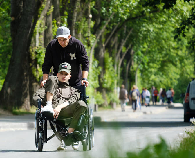 Участник СВО, проходящий лечение в больнице, на прогулке в инвалидной коляске на набережной реки Карповки