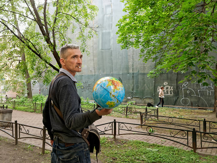 Мужчина с глобусом в центре города