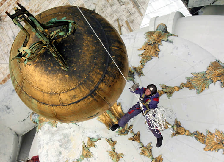 Реставраторы спускаются на вертолете для осмотра купола Смольного собора и обвалившегося на нем креста