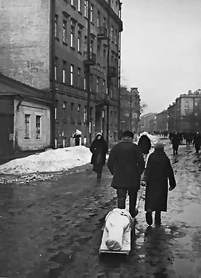 1942 г. Ленинградцы везут на самодельных санках тело умершего от голода родственника