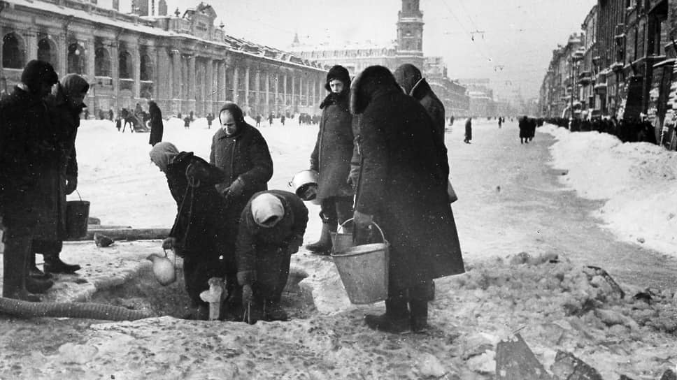1 декабря 1941 г. Ленинградцы набирают воду, появившуюся после артобстрела в пробоинах в асфальте на Невском проспекте