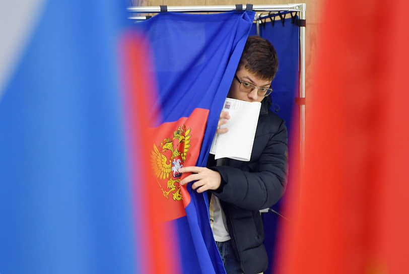 Второй день голосования. Избиратель во время голосования на временном избирательном участке на Московском вокзале
