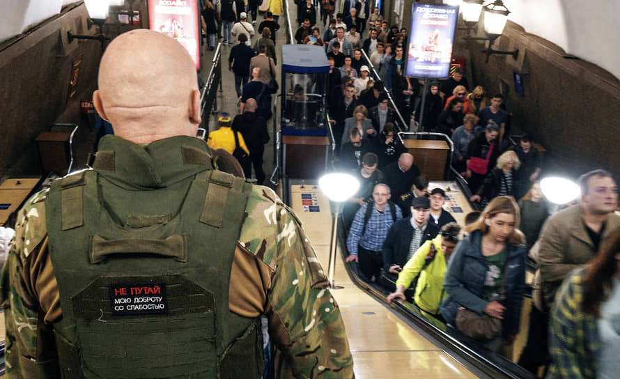 Мужчина в военной форме на эскалаторе метрополитена