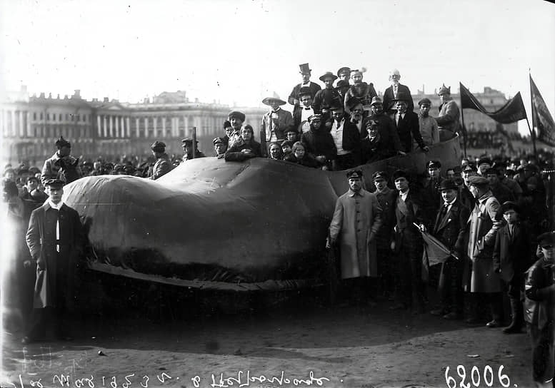 Также с начала 1920-х годов на Первомай начали проводиться костюмированные демонстрации. На снимке запечатлён агитационный автомобиль завода «Красный треугольник» в виде калоши во время первомайской демонстрации 1 мая 1923 года на площади Жертв Революции
