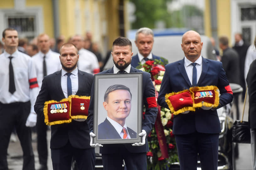 Помощники несли венки и награды бывшего чиновника, полученные им за время работы,— среди них был орден Александра Невского
